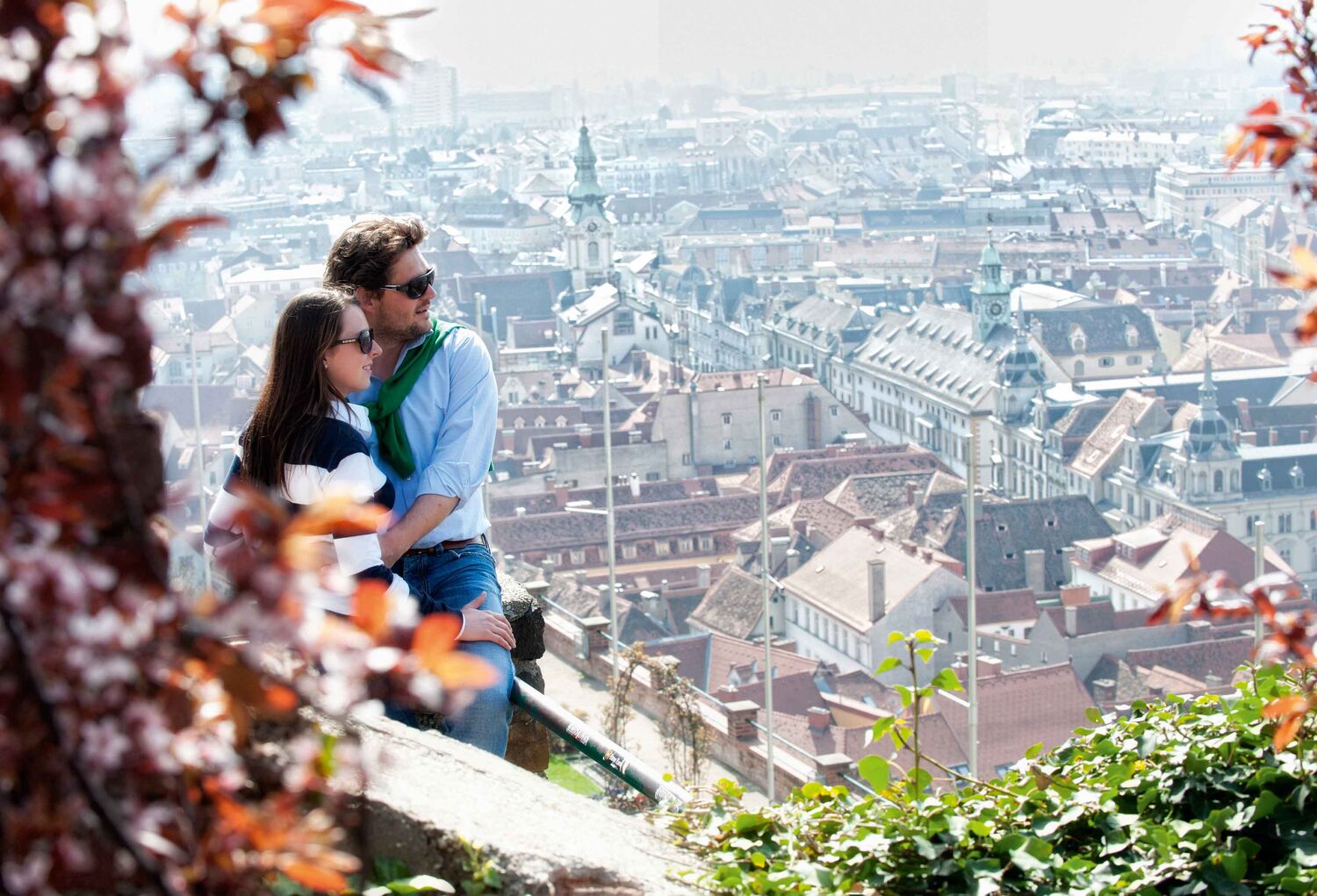 Bild zeigt Paar die den Ausblick auf den Grazer Schlossberg über Graz genießen.