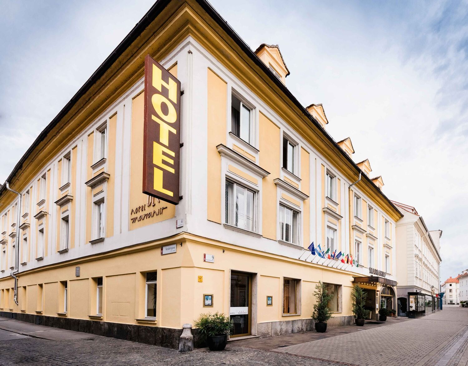 Bild Aussenansicht vom Hotel Mariahilf, ein hellgelbes Haus auf einem Platz.