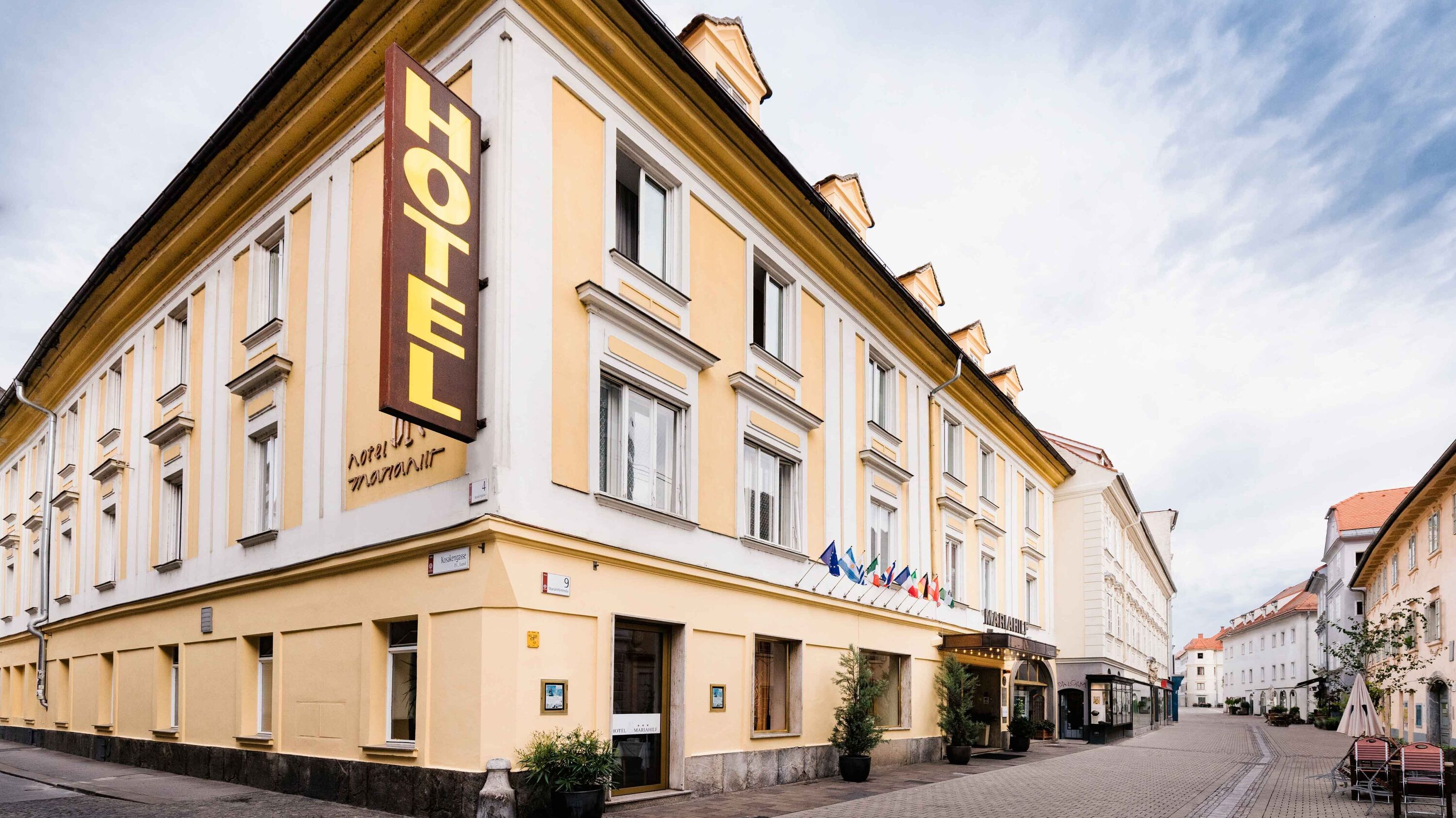 Bild Aussenansicht vom Hotel Mariahilf, ein hellgelbes Haus auf einem Platz.